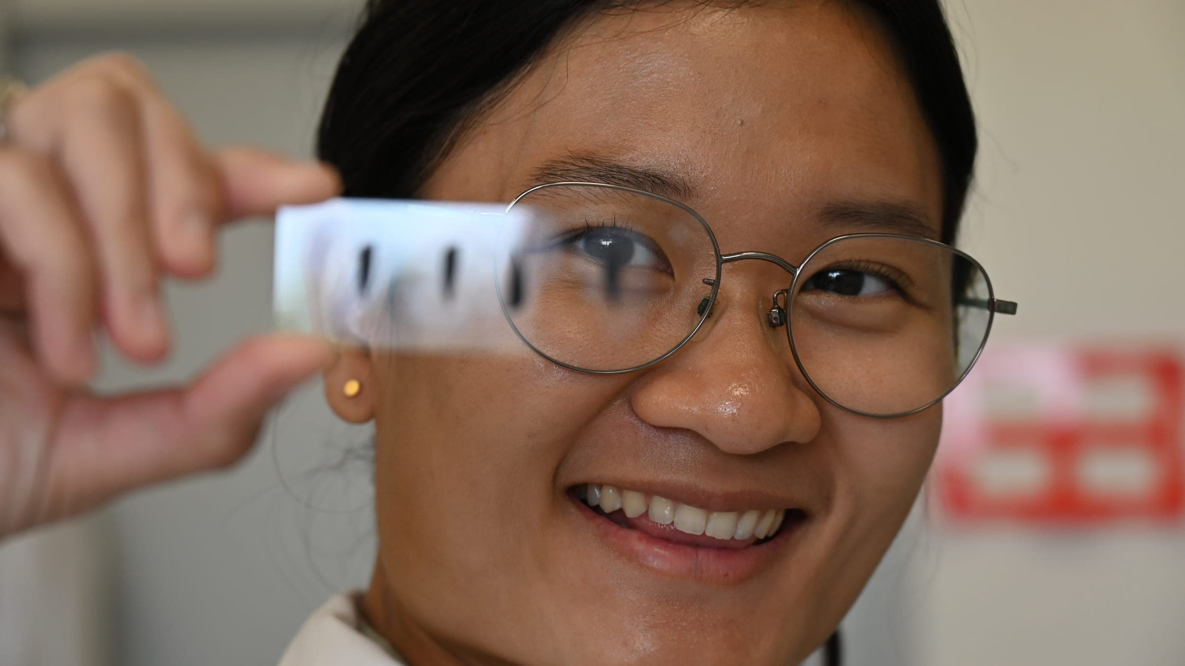 A researcher holding a thin rubber slice up to the light