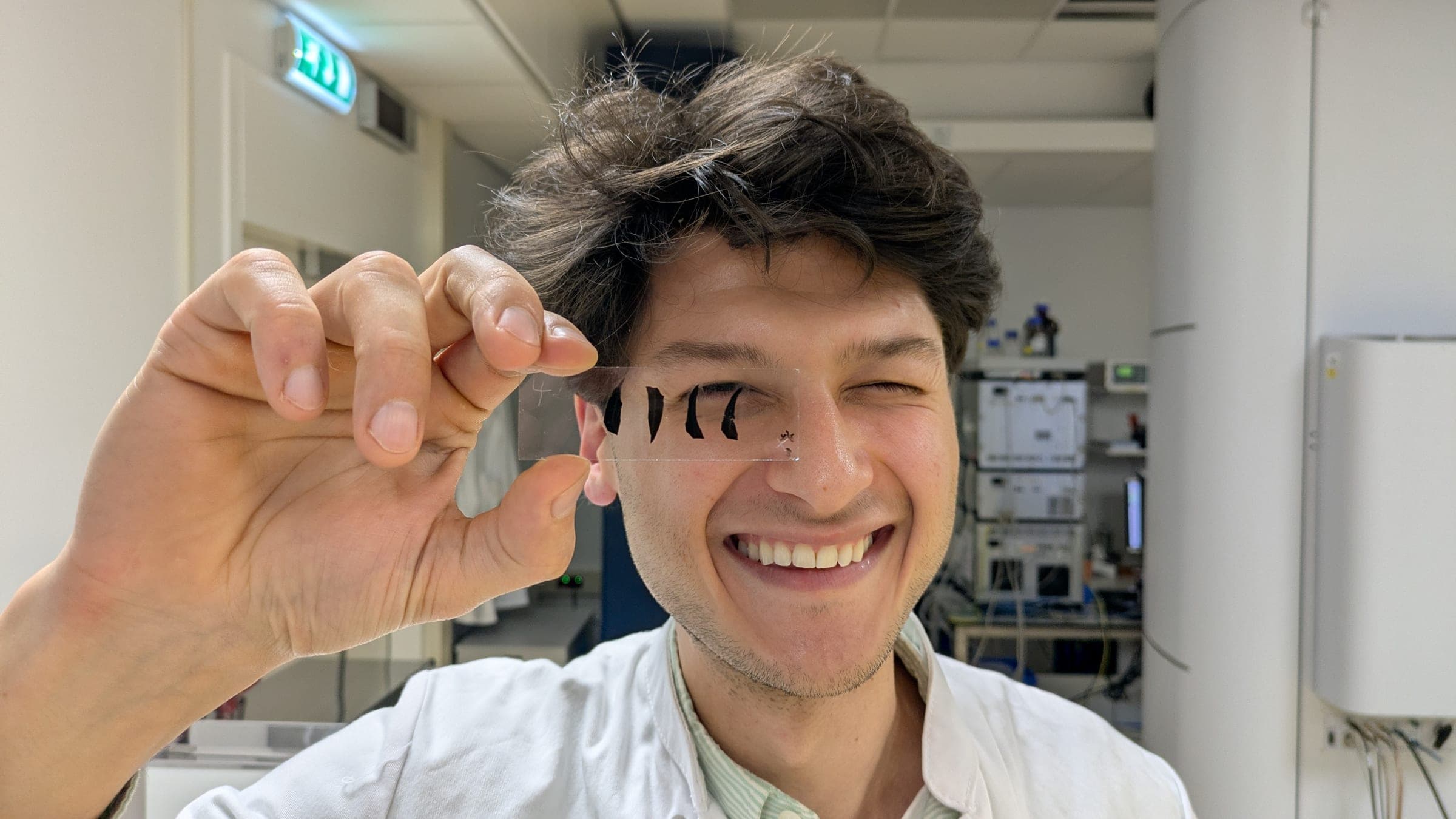 A member of the AKIN team holding a rubber sample in the lab